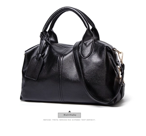 Detail of black lychee grain leather Boston bag featuring gold hardware and shoulder strap