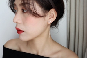 Detail of silver long tassel star threader earrings worn by a model in soft light