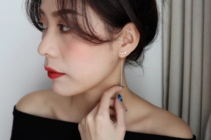 Silver star tassel earrings showing graceful drape and elegant long chain on a model
