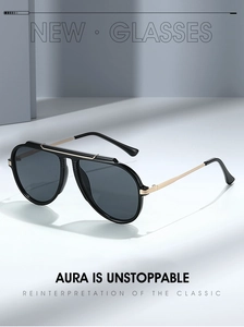Detail of vintage pilot sunglasses with black frame, gold double bridge and dark grey lenses