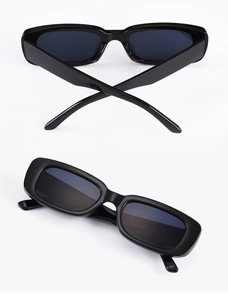 Detail view of vintage narrow rectangular sunglasses with thick black frames and dark lenses