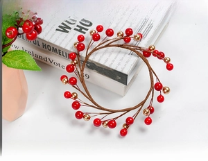 Detailed view of artificial red and gold berry Christmas wreath on decorative books