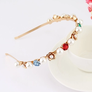 Detailed view of golden headband with pearls, colorful crystals and metal roses