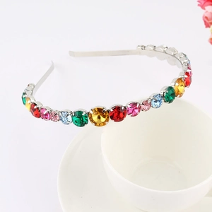 Macro view of multi-colored round rhinestones set on a silver metal baroque headband