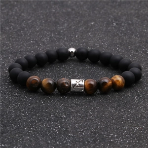 Macro detail of tiger eye beads and matte black stones on a Sagittarius zodiac bracelet