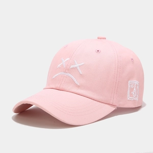 Primer plano de gorra rosa con bordado blanco y costuras detalladas en la visera curva
