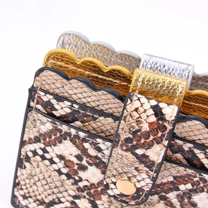 Detail of snake print wallet featuring wave-shaped card slots and metallic finish