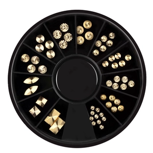Macro view of black nail art carousel wheel with gold metal studs and rivets