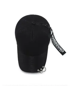 Detail of black baseball cap with metallic rings on brim and printed street style ribbon
