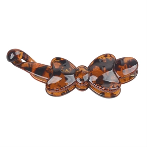 Detailed view of the tortoiseshell resin bow banana hair clip with glossy brown finish