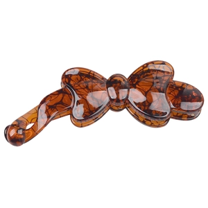 Detailed close-up of brown tortoise shell resin banana clip with elegant bow design