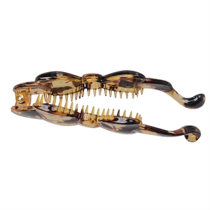 Close-up of tortoise shell resin banana hair clip with dense teeth and metal spring