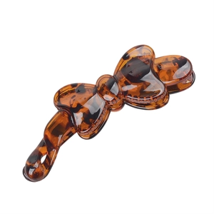 Detail shot of the glossy tortoiseshell resin finish on the bow banana hair clip