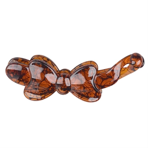 Detailed view of amber tortoise shell pattern on a resin bow-shaped banana hair clip