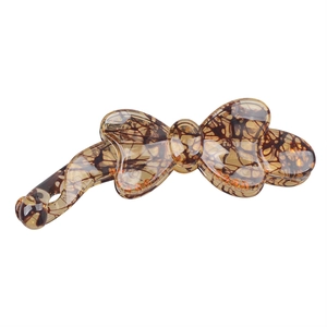 Macro view of leopard print resin banana hair clip showing glossy finish and texture