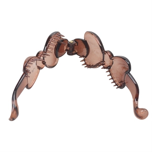 Detail view of an open brown resin banana clip showing internal comb teeth for hair grip