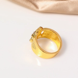 Detail of a wide gold-toned hip hop ring featuring clear crystals and side cutouts