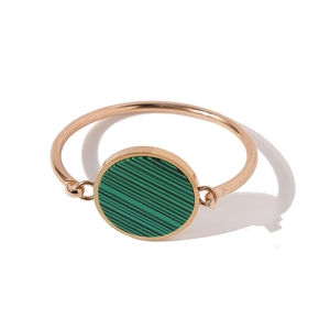 Detailed close-up of rose gold bracelet with circular green malachite stone inlay