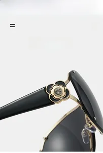 Macro detail of gold metal sunglasses frame with camellia floral hinge and crystal inlay
