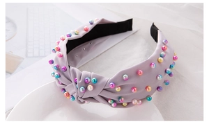 Close-up of a knotted light purple fabric headband with colorful faux pearl beads
