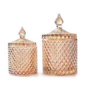 Set of two amber glass storage jars with lids featuring diamond cut texture on white base