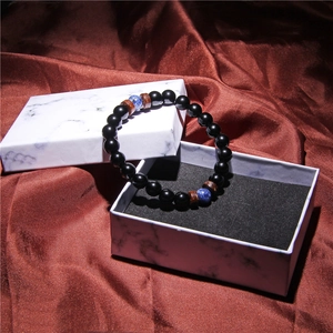 Men's volcanic stone and coconut wood bracelet presented in a marble gift box on satin