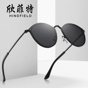 Detail view of retro oversized black round sunglasses with sleek metal temples on geometric background