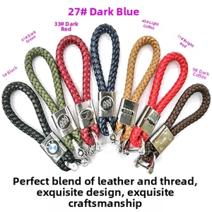 Macro shot of colorful woven leather car keychains with various luxury metal logos