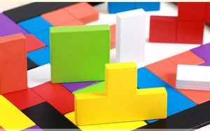 Close-up of colorful geometric wooden puzzle blocks with smooth matte finish texture