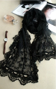 Close-up of black lace scarf with intricate floral embroidery and scalloped crochet edges