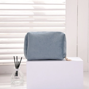 Detailed view of the blue velvet cosmetic bag with gold zipper and premium texture