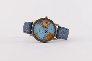 Detail of world map watch dial with bronze case and blue denim strap in a high-quality close-up
