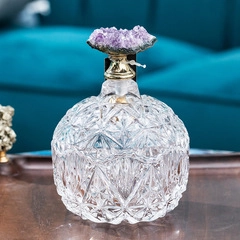 Detail einer kugelförmigen Glasflasche mit Amethyst-Naturstein und goldenem Kragen
