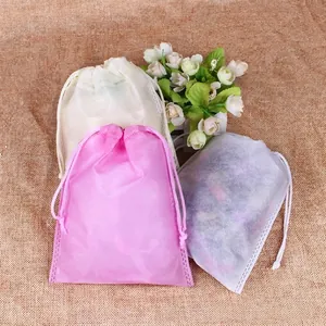 Non-woven drawstring storage bags in pink and white for shoes and clothes protection