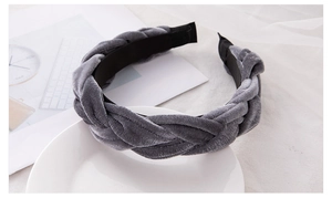 Detail of dark grey velvet braided headband on white ceramic plate with vintage vibes