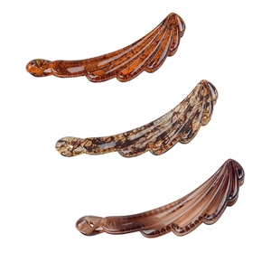 Three-piece banana hair clip set in amber and tortoiseshell resin on white background