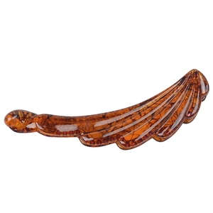 Detailed view of an amber resin banana hair clip with elegant feathered wave texture