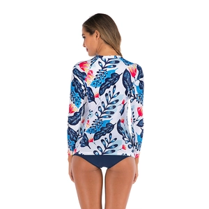 Detail view of long-sleeve bikini swimwear with tropical leaf and red floral pattern