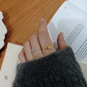 Detail of adjustable leaf rings in gold and silver finish with sparkling zircons