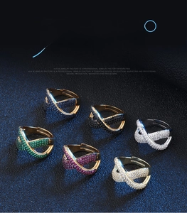 Dettaglio di anelli regolabili con zirconi colorati e design incrociato micro-pave