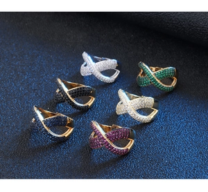 Dettaglio di anelli infinito con pavé di zirconi colorati in finitura oro e argento