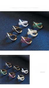 Dettaglio di eleganti anelli a incrocio a X con pavé di zirconi colorati scintillanti