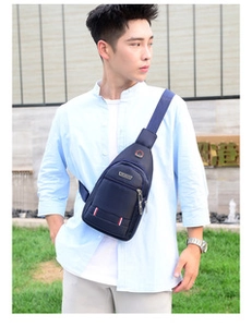 Outdoor shot of man wearing a deep blue waterproof chest bag with adjustable shoulder strap