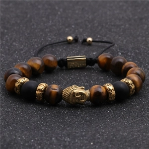 Dettaglio del ciondolo testa di Buddha e perle occhio di tigre su bracciale intrecciato