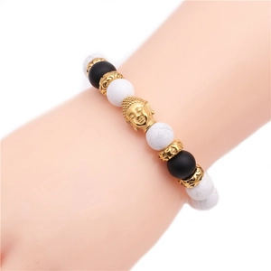 Dettaglio del bracciale con perline di turchese bianco, perle nere e ciondolo testa di Buddha