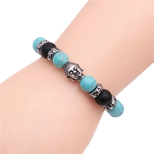 Dettaglio di perline turchesi e testa di Buddha in argento su bracciale intrecciato da uomo