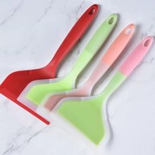Detailed view of four colorful silicone spatulas arranged on a white marble surface