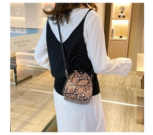 Rear view of a mini snakeskin print crossbody bag with black handle and shoulder strap