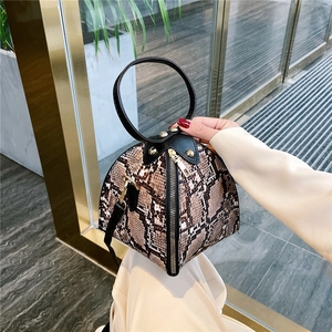 Fashionable snake print geometric triangular handbag with gold hardware and top handle