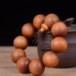 Close-up of 25mm sandalwood beads with natural grain and traditional Chinese knot